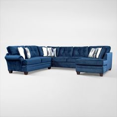 a blue sectional couch with pillows on it