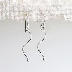 Our Sterling Silver Dangly Simple Wave Earrings are a fantastic pair of fun, every day earrings These light and delicate sterling silver earrings would add a subtle touch of elegance to any outfit or occasion. They're design and polished finish gives them a wonderfully understated presence and shine. So why not treat some family or friends to these great little earrings, priced so well you could even treat yourself. All Martha Jackson jewellery comes complete with a gift box and gift card for you to write a short message on Made from Sterling Silver, keep shiny with an anti tarnish cloth Dimensions Wave length 3cm. Overall length 4.2cm Dainty Silver Drop Wrap Earrings, Everyday Silver Earrings With A Modern Twist, Modern Twist Silver Earrings For Everyday, Sterling Silver Drop Earrings With A Modern Twist, Modern Twist Sterling Silver Drop Wrap Earrings, Modern Twist Sterling Silver Drop Earrings, Teardrop Earrings With A Modern Twist As A Gift, Modern Twist Teardrop Earrings Gift, Modern Twist Dangle Earrings As Gift