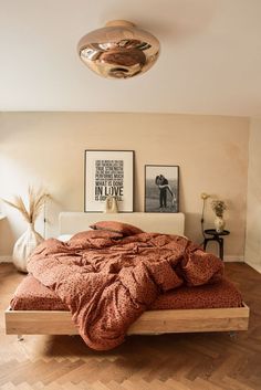 a bed with an orange comforter on top of it