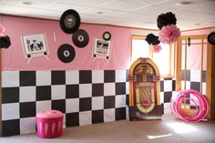 a room decorated in pink, black and white with an old fashioned jukebox