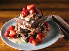 a stack of chocolate waffles with strawberries on top