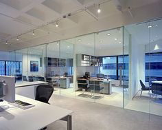 an office with glass walls and desks