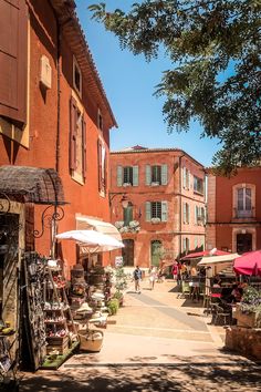 an alley way with tables and umbrellas on both sides