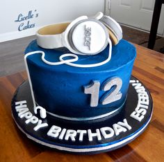 a blue birthday cake with headphones on top and the number twelve in white icing