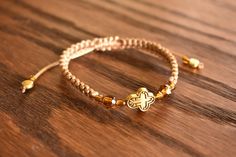 a bracelet with a cross on it sitting on top of a wooden table