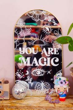 there is a sign that says you are magic on the shelf next to some toys