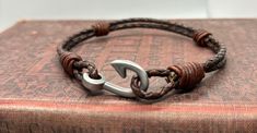 Fisher of Men Collection This was designed with the men or women in mind who love to fish and who love the open sea.  The fishhook has many symbolic meanings besides the obvious.  In the islands it is a symbol for captured and enduring love, and for men and women of faith it is the call to a deep love of others.   Made with Natural Brown 3mm braided leather cord with an antique fish hook. Thank you for shopping at deZigns for Life.  As always 10% of profits go toward funding adoption. Fishers Of Men Bracelet, Fish Hook Bracelet, Faith Bracelet, Hook Bracelet, Bracelet Knots, Macrame Bracelets, Fish Hook, Natural Brown, Braided Leather