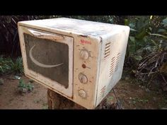 an old microwave sitting on top of a tree stump