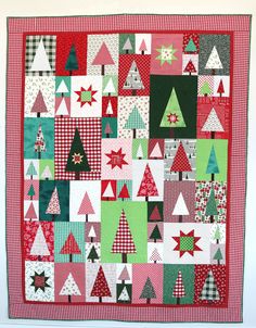 a red and green christmas quilt hanging on a wall