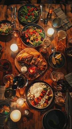 an overhead view of a table full of food and drinks with candles on the side