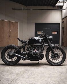 a black motorcycle parked inside of a garage