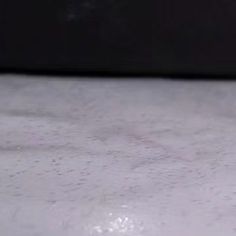 a close up view of the surface of a white counter top with water droplets on it