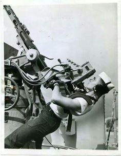 an old black and white photo of a man working on machinery