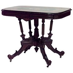 an antique wooden table with marble top on wheels and turned legs, isolated against a white background