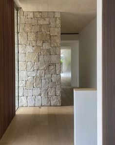 the interior of a house with wood and stone on the walls, along with wooden flooring