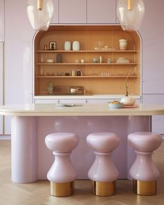 an island with stools in front of it and shelves on the wall behind it