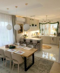 a dining room table and chairs in front of a kitchen