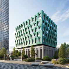 a large green building sitting on the side of a road next to some tall buildings