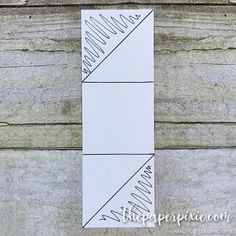 a bookmark with lines drawn on it sitting on top of a wooden table next to a wall