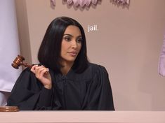 a woman sitting at a desk with a judge's robe on