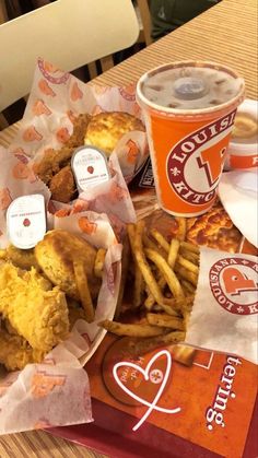 fried chicken and french fries are on a tray next to a cup of soda at a fast food restaurant