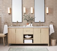 a bathroom with two sinks and mirrors on the wall next to a rug in front of it