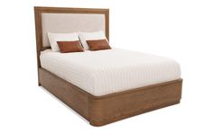 a bed with two pillows on top of it and a wooden frame around the headboard