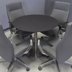 a round table with four chairs around it in an office setting or conference room area