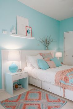 a bed room with a neatly made bed and blue walls