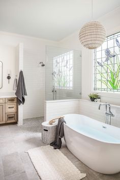 a large white bath tub sitting next to a window