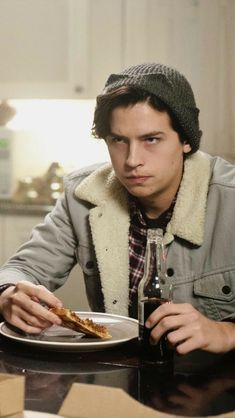 a man sitting at a table with a plate of food in front of his face