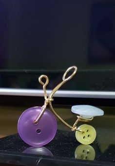 a pair of yellow and purple buttons sitting on top of a black table next to a computer monitor