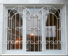 a white window with iron bars on it