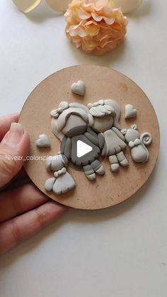 a hand holding a piece of art made out of clay