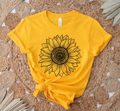 Sunflower Shirt, Sunflower T-Shirt Floral Tee Shirt Flower Shirt Garden Shirt Womens Fall Shirt Sunflower Tshirt Sunflower Shirts Sunshine This unisex t-shirt fits like a well-loved favorite. It has a soft and light feel, with just the right amount of stretch. * Made of combed and ring-spun cotton * Comfortable and flattering for both men and women SIZING * See sizing chart illustration. * If unsure as to what size to order, lay a favorite t-shirt flat and measure from armpit to armpit (width) a Sunflower T Shirt Design, Yellow Sunflower Design Top For Spring, Relaxed Fit Short Sleeve Shirt With Sunflower Print, Relaxed Fit Cotton Tops With Sunflower Design, Cotton Tops With Sunflower Design And Relaxed Fit, Sunflower Shirt Ideas, Spring Short Sleeve Shirt With Sunflower Print, Spring Sunflower Design Top With Short Sleeves, Relaxed Fit Cotton Top With Sunflower Design