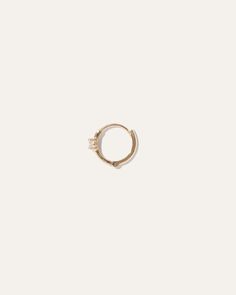 Our classic solo mini hoop, with a colorful twist. Each 14k gold hoop is set with a genuine ruby, white, or blue sapphire for a touch of bling. Sold as a single earring.  | Quince | Women's 14k Gold Gemstone Solo Mini Hoop Earring in White Sapphire Minimalist Hoop Jewelry With Halo Detail, Minimalist Hoop Jewelry With Halo, 14k Gold Halo Huggie Earrings, Everyday Yellow Gold Huggie Earrings With Birthstone, Minimalist Hoop Earrings With Halo, Small Hoop Earrings With Single Diamond In 14k Gold, Minimalist Small Hoop Jewelry With Halo, Minimalist Small Hoop Halo Jewelry, Small Hoop Single Diamond Fine Jewelry