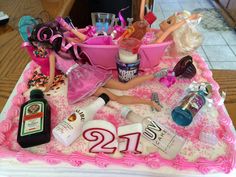 a birthday cake decorated with barbie dolls and cosmetics