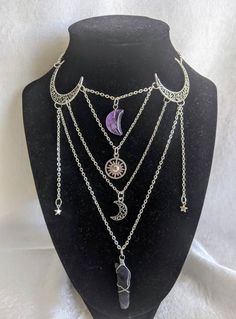 This gorgeous necklace looks like a layered piece, but is actually all in one! No hassle of putting on/taking off multiple necklaces, this piece gives off a witchy, magical look. The necklace features moons, stars, a sun, and a crystal moon and stick arranged in a uniquely magical way! Perfect for special occasions or to add a little magic to your everyday Choose between silver and bronze Choose between an amethyst moon and stick or a clear quartz moon and stick The shortest chain measures at 16 Mystical Silver Choker Necklace, Silver Witchy Choker Jewelry, Bohemian Moon Charm Jewelry For Party, Mystical Metal Necklaces For Festivals, Mystical Metal Necklace For Festivals, Mystical Metal Necklaces For Parties, Witchy Choker Necklace Gift, Bohemian Silver Crystal Clavicle Chain Necklace, Bohemian Silver Crystal Necklace With Clavicle Chain