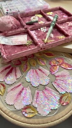 a table topped with lots of pink and gold decorations on top of a wooden table