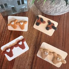 four different shaped pastries sitting on top of a wooden table next to a potted plant