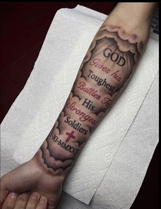 a person with a tattoo on their arm that says god and two other words in the sky