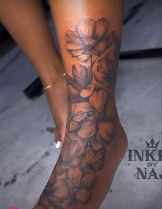 a woman's leg with flowers and butterflies on it