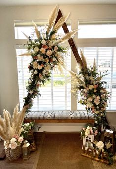 an arch decorated with flowers and pamodia in front of a window on a rug