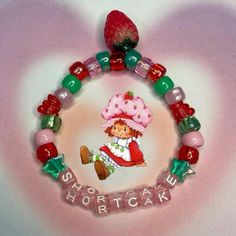 a close up of a beaded bracelet on a white surface with the words shortcake spelled in small letters