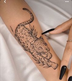 a black and white tattoo of a leopard on the leg