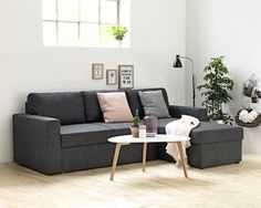 a living room with a black couch and coffee table next to it on hard wood flooring