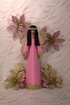 a pink doll with black hair and gold accents