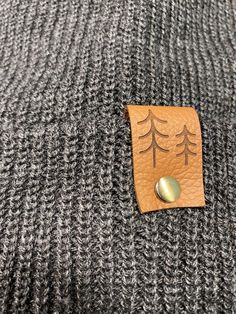 Give the gift of warmth and style! This knit beanie is perfect for hiking, camping, and perfect for keeping warm! Beanie is a dark charcoal gray color, and is made of a soft wool/acrylic blend. Attached is an engraved leather label tag with a brass rivet. The leather label is engraved on both sides, so whether you wear the hat with the brim up or down, the label will still show the design in the correct orientation. Choice of circle logo or trees available at checkout. Care - Hand wash, dry flat Gray Warm Beanie For Outdoor, Warm Gray Beanie For Outdoor, Warm Hat For Outdoor Fall Use, Warm Gray Hats For Outdoor, Warm Gray Hat For Outdoor, Gray Hats For Winter Outdoor Activities, Gray Hats For Outdoor Winter Activities, Gray Hats For Outdoor Activities In Winter, Gray Winter Hats For Outdoor