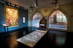 a room with two paintings on the wall and a large rug in front of it