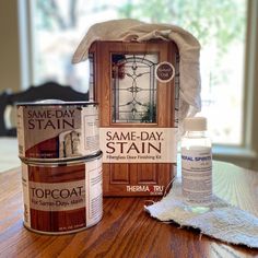 some paint sitting on top of a wooden table next to a can of stainer